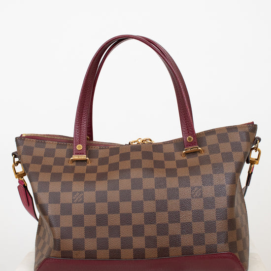 Brown checkered handbag with red accents on a white background