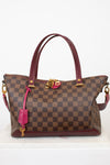 Brown checkered handbag with pink accents on a white background