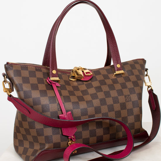 Designer handbag with checkered pattern and red accents on a white background