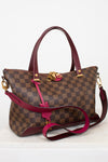 Designer handbag with checkered pattern and red accents on a white background