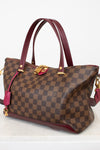 Brown checkered handbag with red accents on a white background