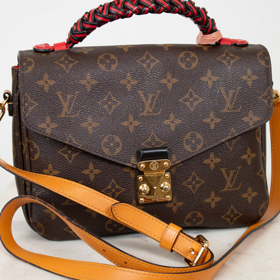 Designer handbag with monogram pattern on a white background