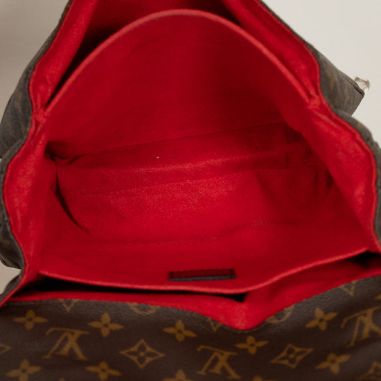 Brown leather bag with red interior, featuring a brand logo.