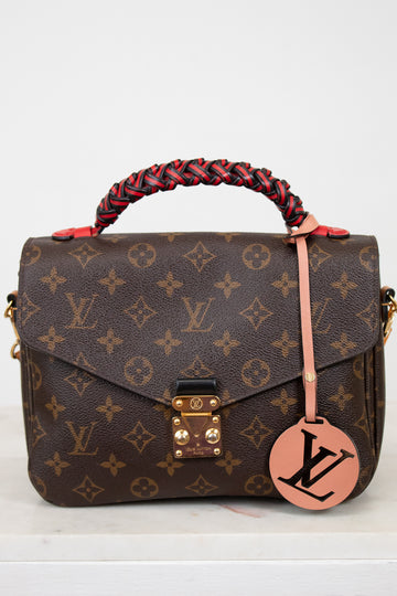 Designer handbag with monogram pattern on a white background