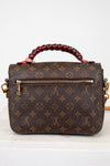 Brown handbag with a monogram pattern on a white background