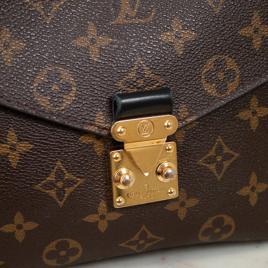 Louis Vuitton monogram handbag with gold lock on a marble surface