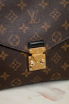Louis Vuitton monogram handbag with gold lock on a marble surface