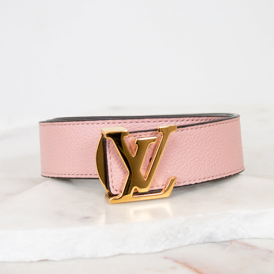 Pink belt with gold buckle on a white background