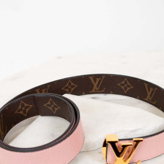 Louis Vuitton belt with pink strap and gold buckle on a white background
