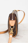 Close-up of a brown leather handbag with gold accents on a light background