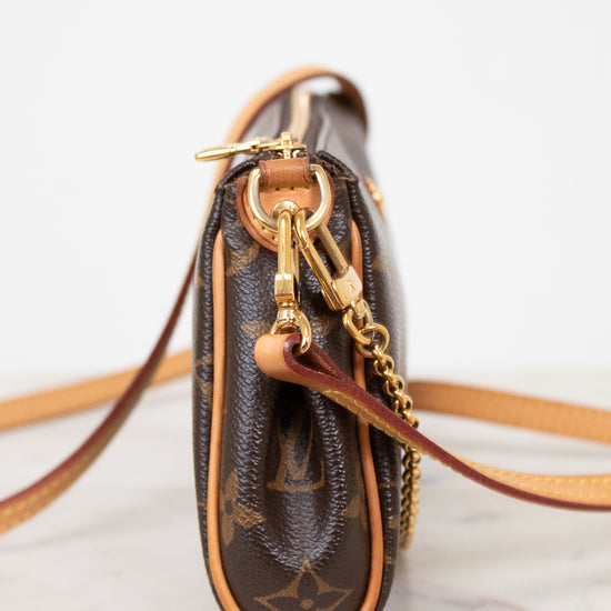 Brown handbag with gold chain and clasp on a light background