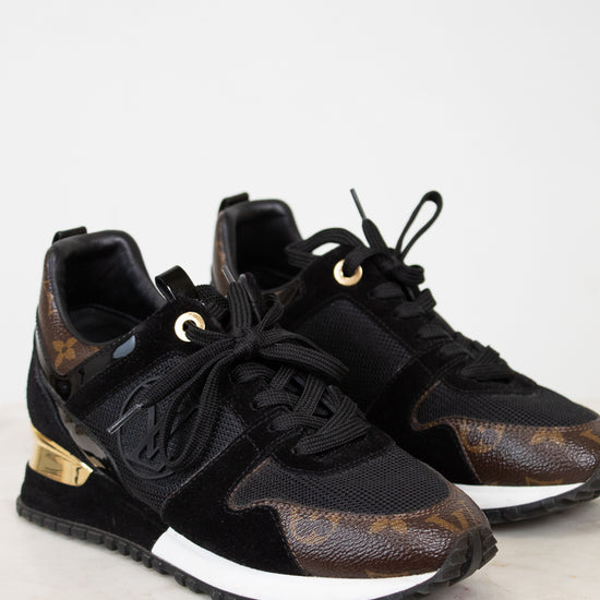 Black and brown sneakers with gold accents on a white background