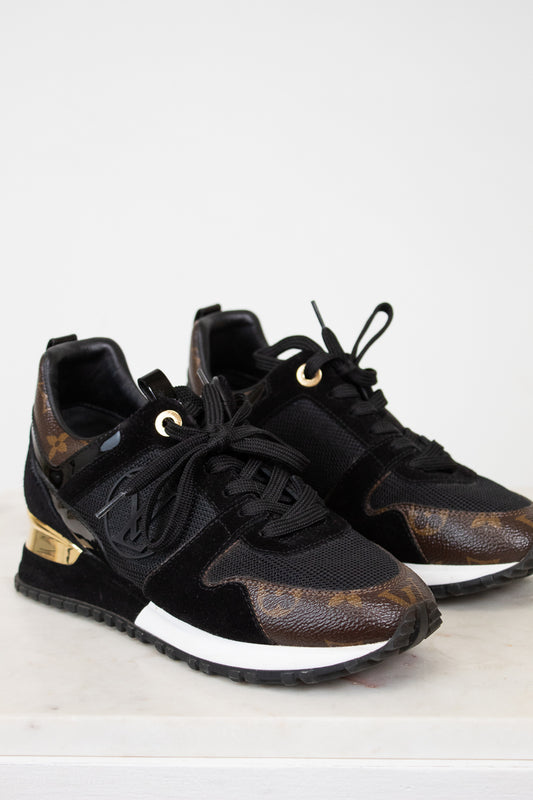 Black and brown sneakers with gold accents on a white background