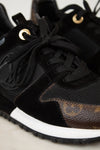 Black sneaker with brown accents on a light background