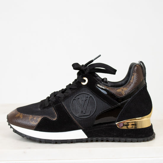 Black sneaker with gold accents on a white background
