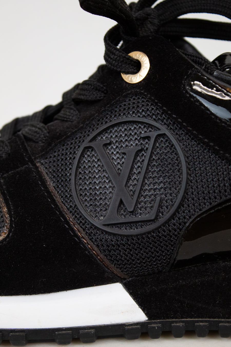 Black sneaker with a brand logo on a white background