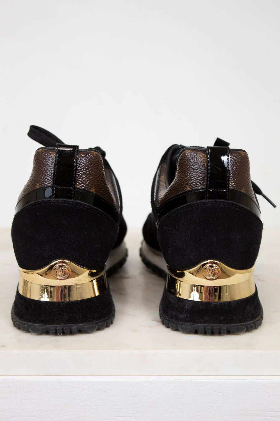 Black shoes with gold accents on a white background