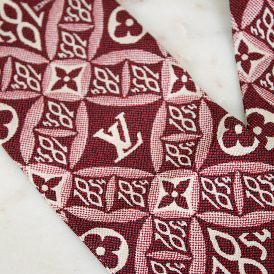 Close-up of a red and white patterned fabric with a logo on a marble surface