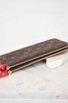 Louis Vuitton wallet with monogram pattern on a marble surface