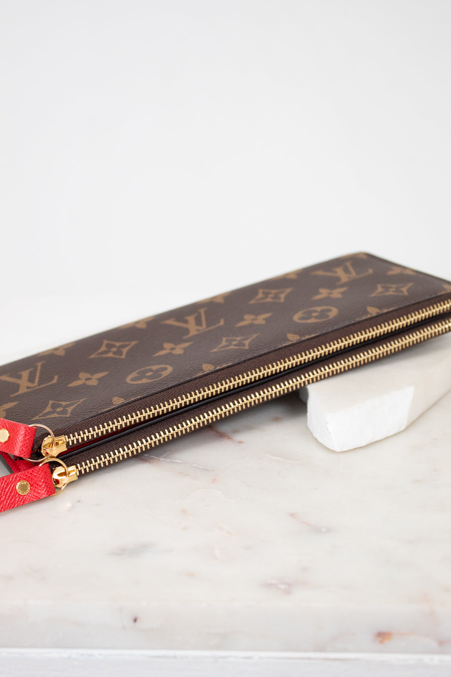 Louis Vuitton wallet with monogram pattern on a marble surface