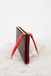 Louis Vuitton wallet with red interior and zipper details on a white surface