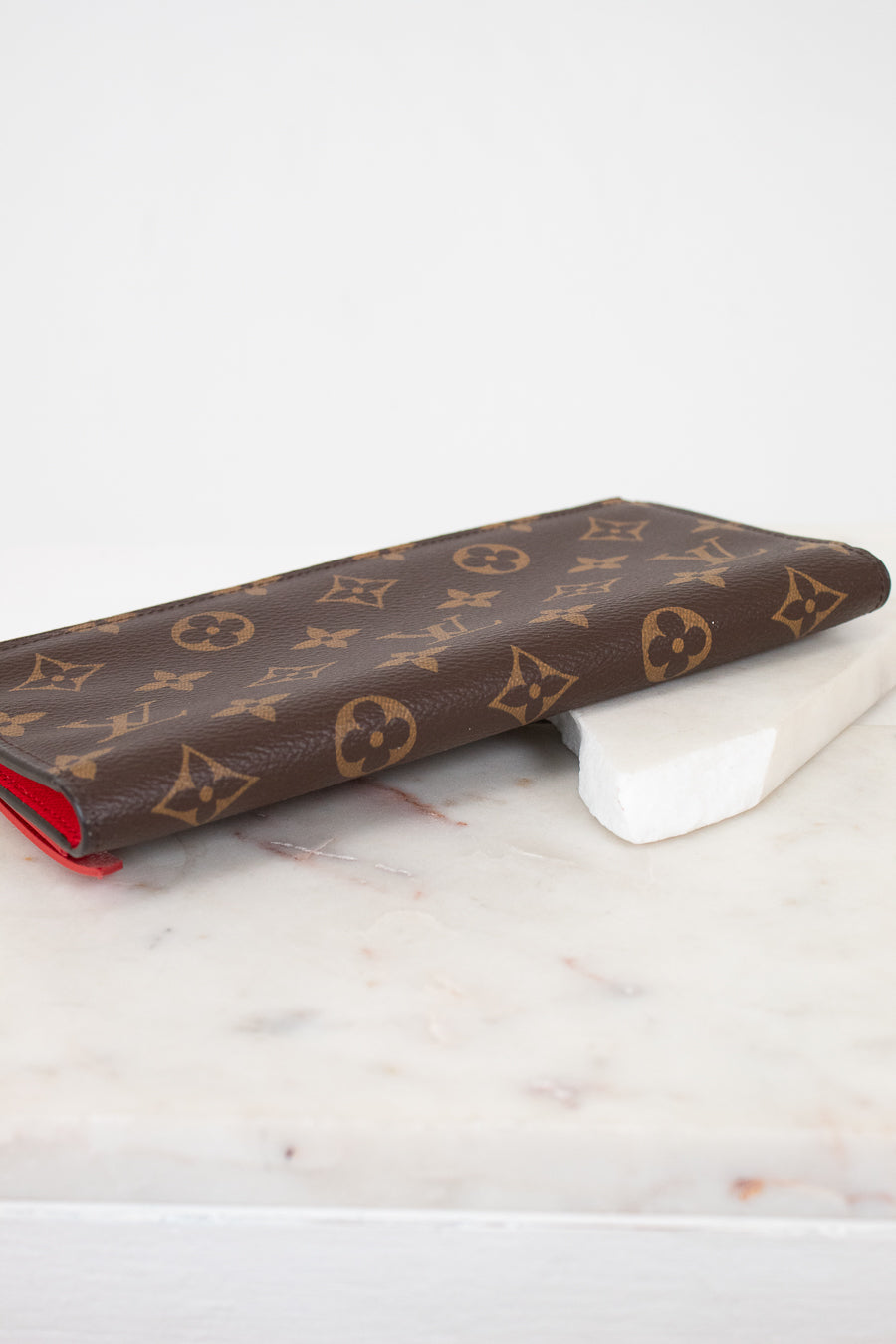 Louis Vuitton wallet with monogram pattern on a marble surface