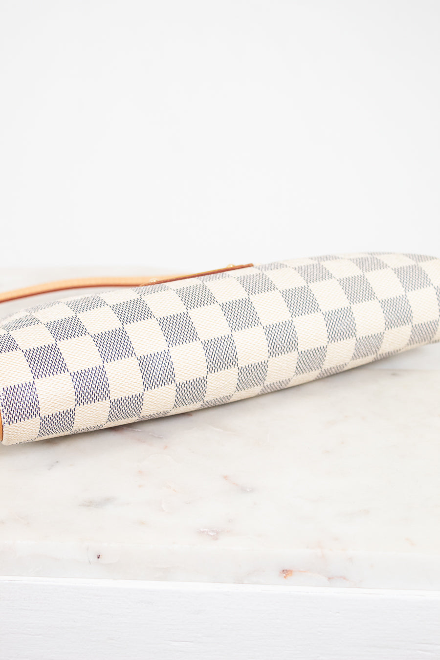 Checkered clutch bag on a marble surface