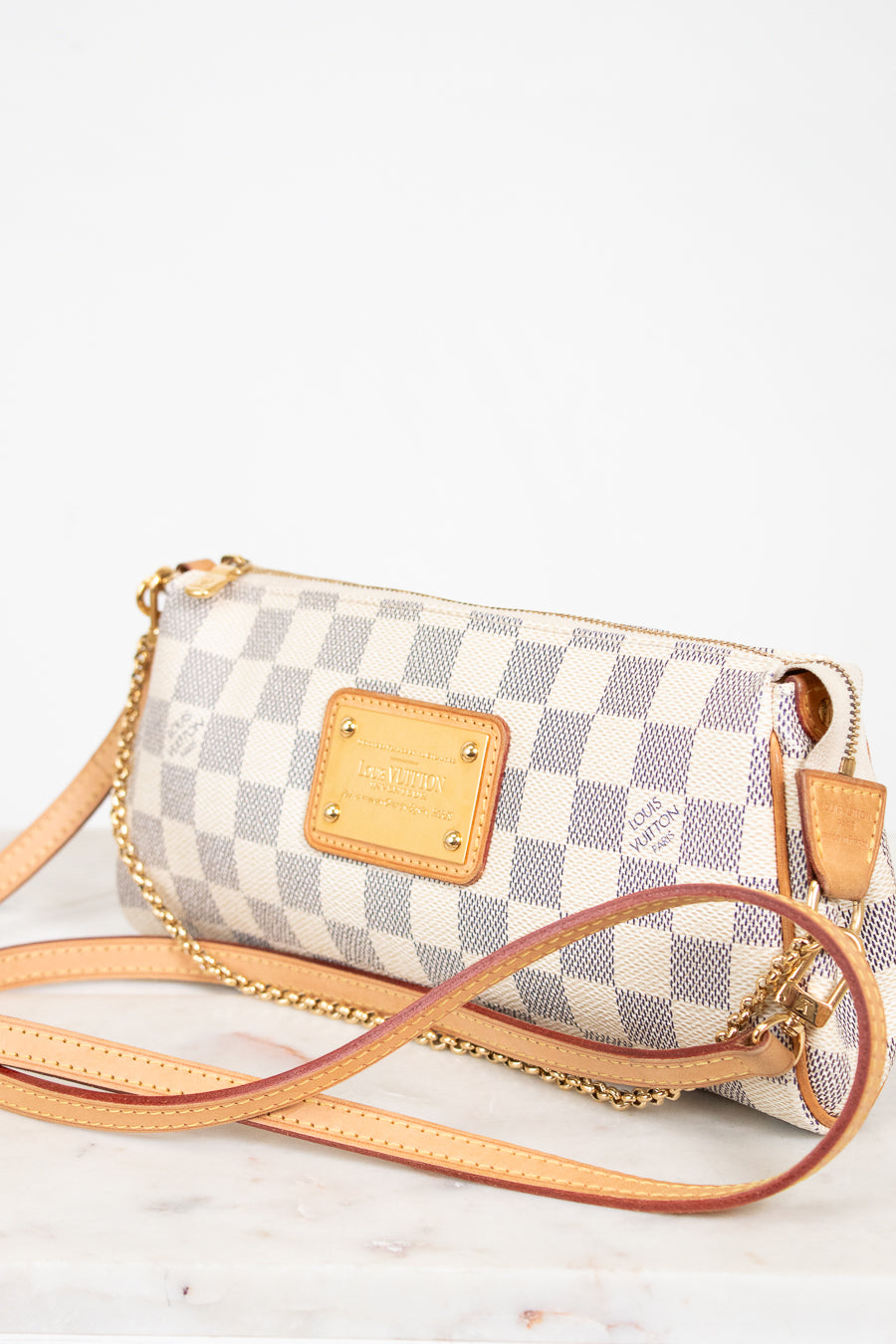 Checkered handbag with gold accents on a white background