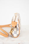 Small checkered handbag with beige strap on a light background