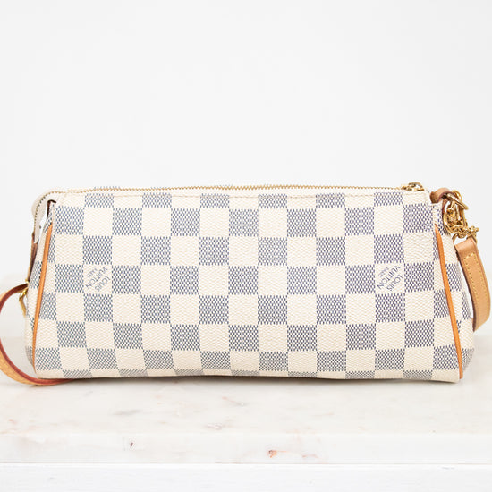 Checkered handbag with gold accents on a white background