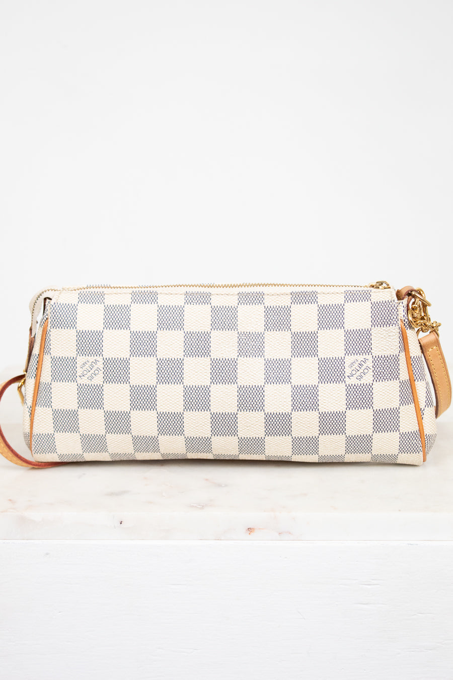 Checkered handbag with gold accents on a white background