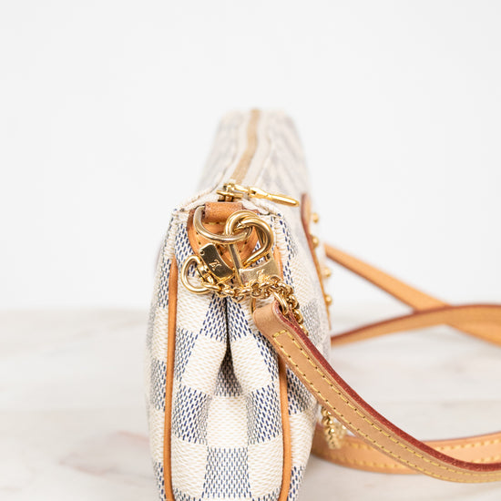 Small handbag with checkered pattern and gold accents on a white background
