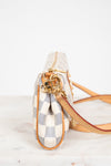 Small handbag with checkered pattern and gold accents on a white background