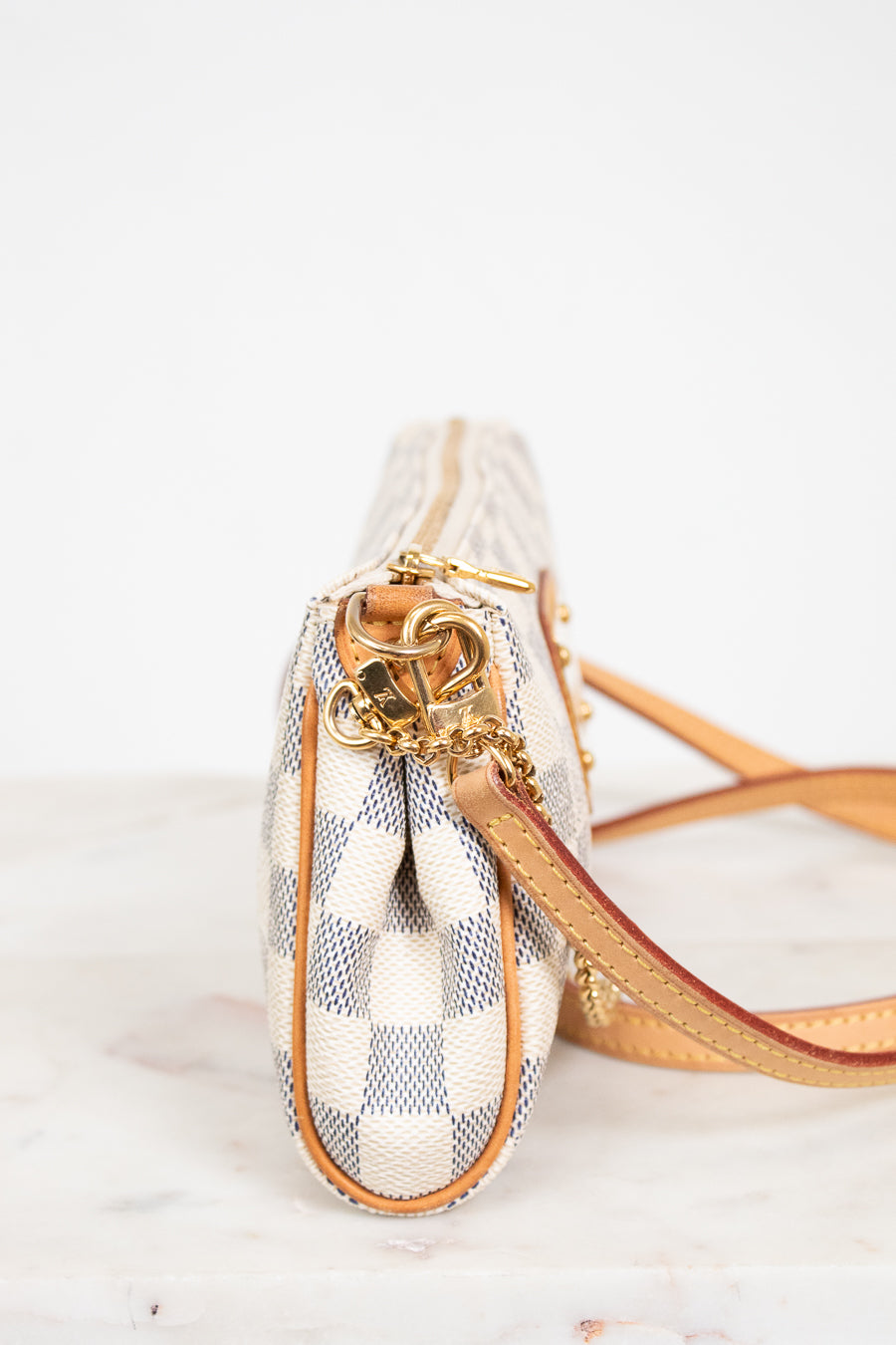 Small handbag with checkered pattern and gold accents on a white background