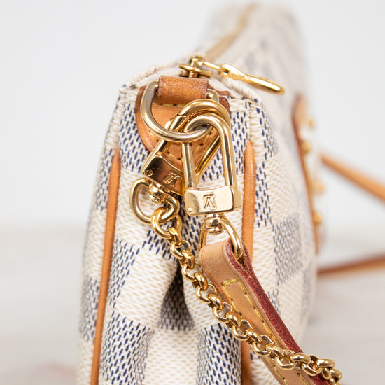 Close-up of a checkered handbag with gold chain and strap on a light background