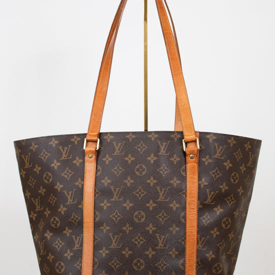 Designer handbag with monogram pattern on a white background