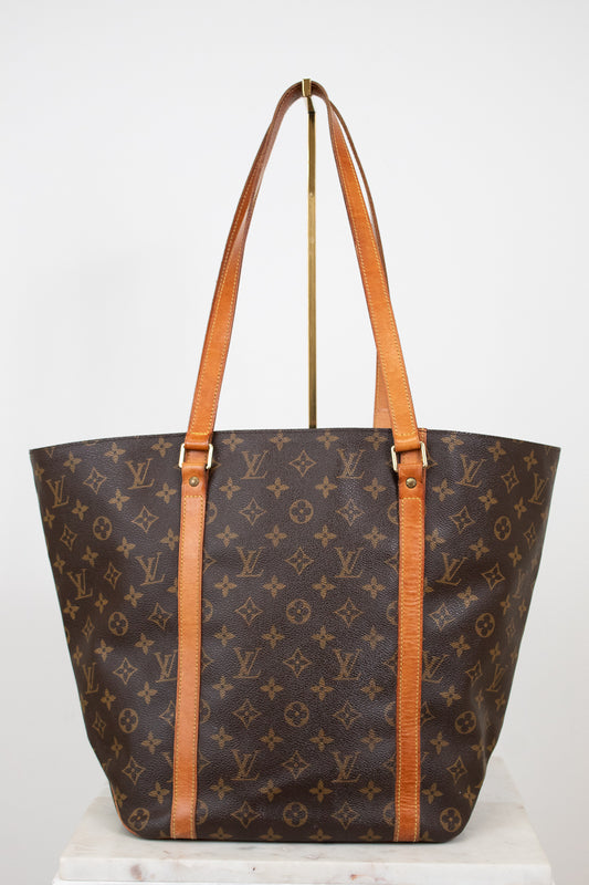 Designer handbag with monogram pattern on a white background