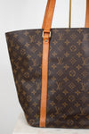 Louis Vuitton monogram handbag with brown leather straps on a white background
