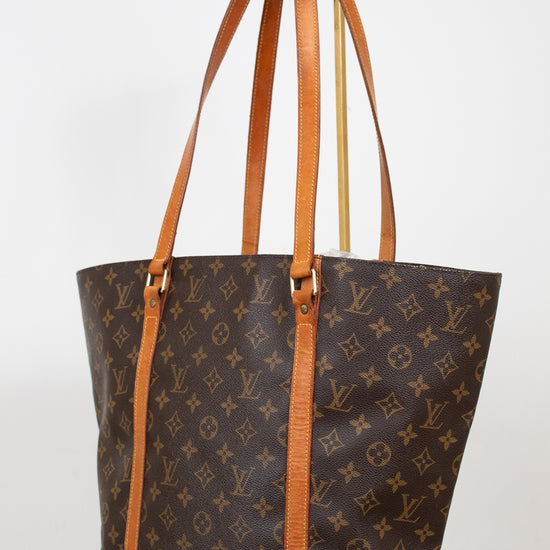 Designer handbag with monogram pattern on a white background