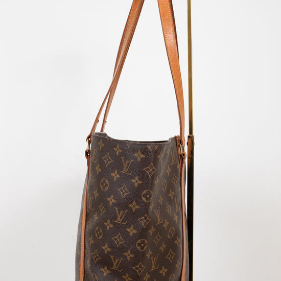 Brown leather handbag with monogram pattern on a white background