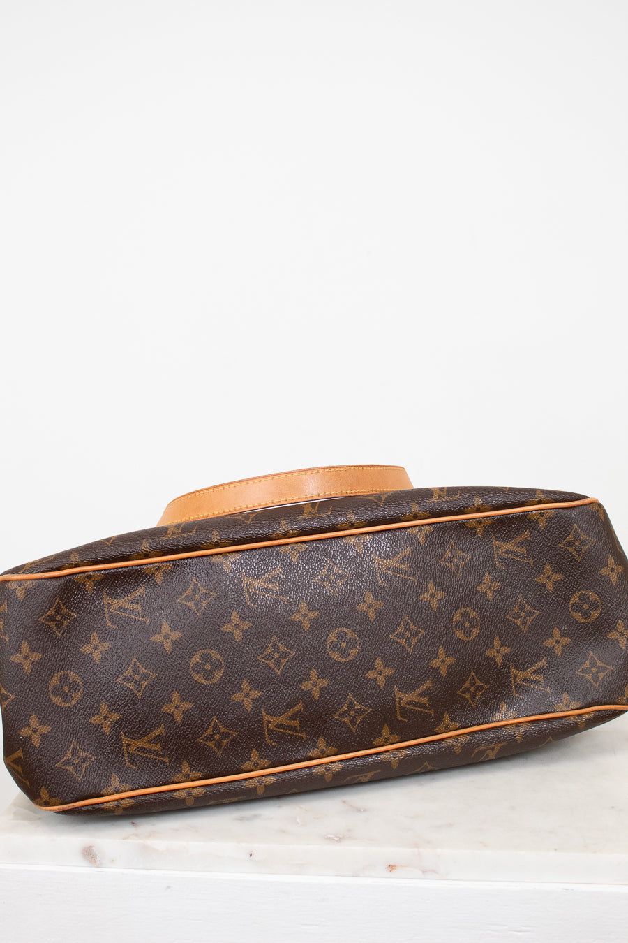 Designer handbag with monogram pattern on a white background