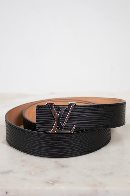 Black and brown belt with a prominent Louis Vuitton logo on a light marble background