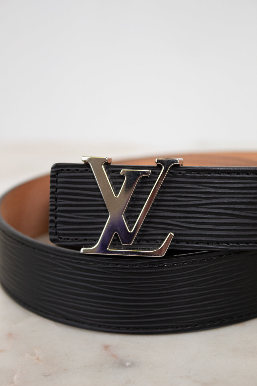 Black belt with a silver buckle on a light background