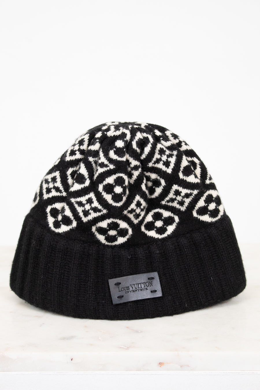Black beanie with white pattern on a white background