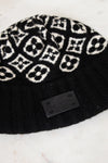 Black beanie with white pattern on a marble surface