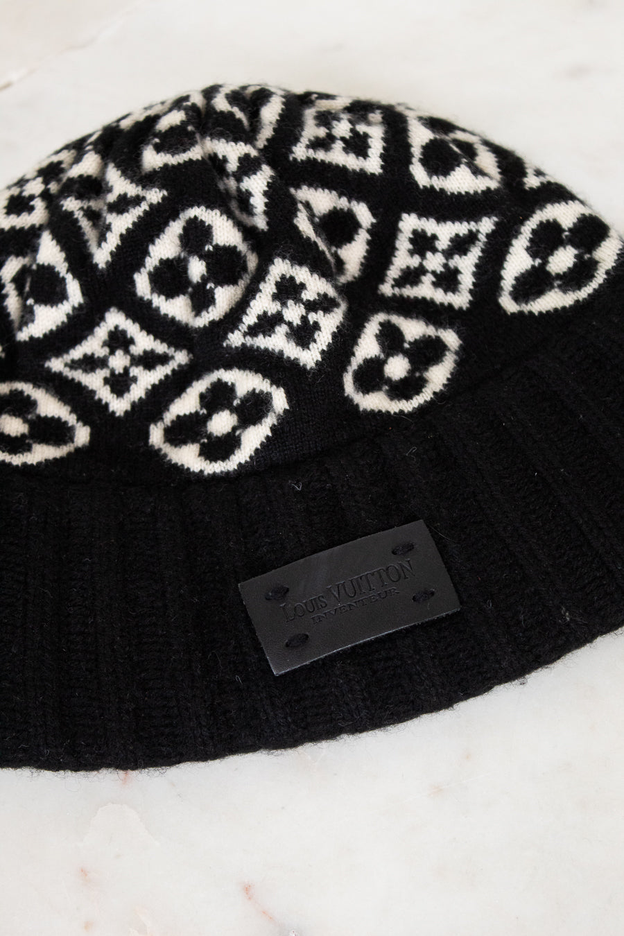 Black beanie with white pattern on a marble surface