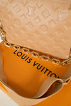 Louis Vuitton beige handbag on orange box with brand logo 