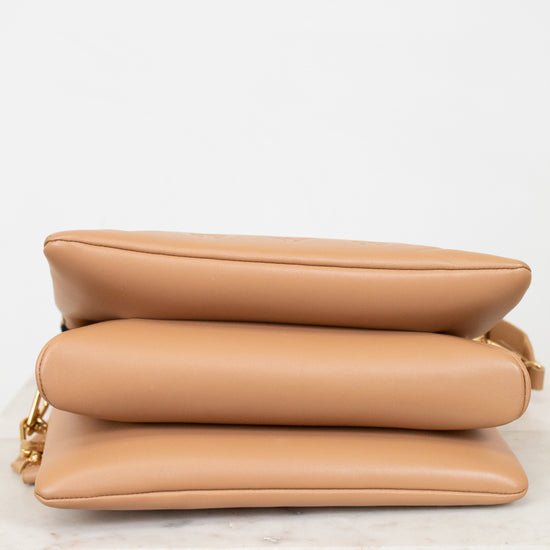 Tan handbag on a light surface with a white background