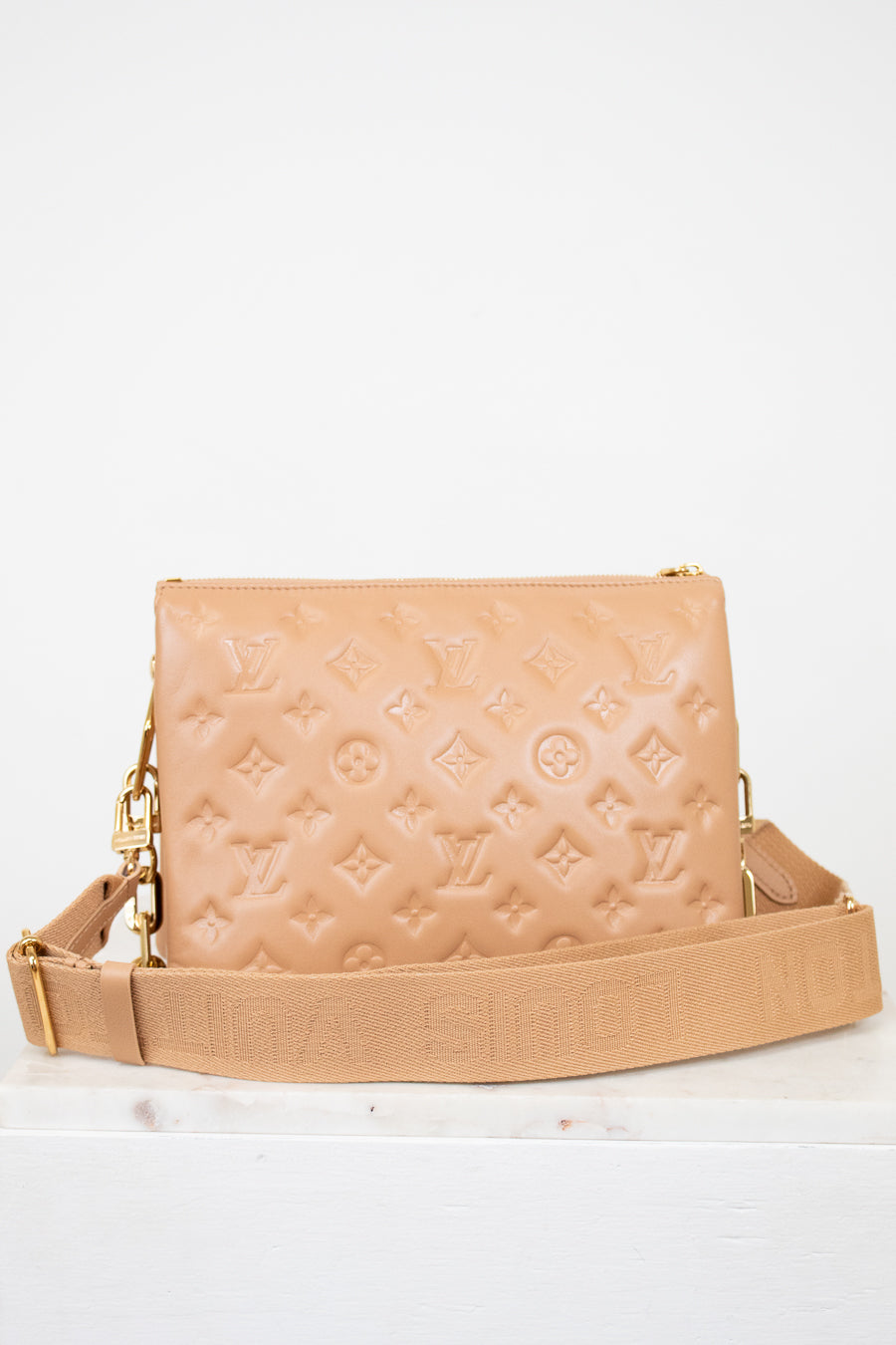 Beige handbag with brand logo on a white background