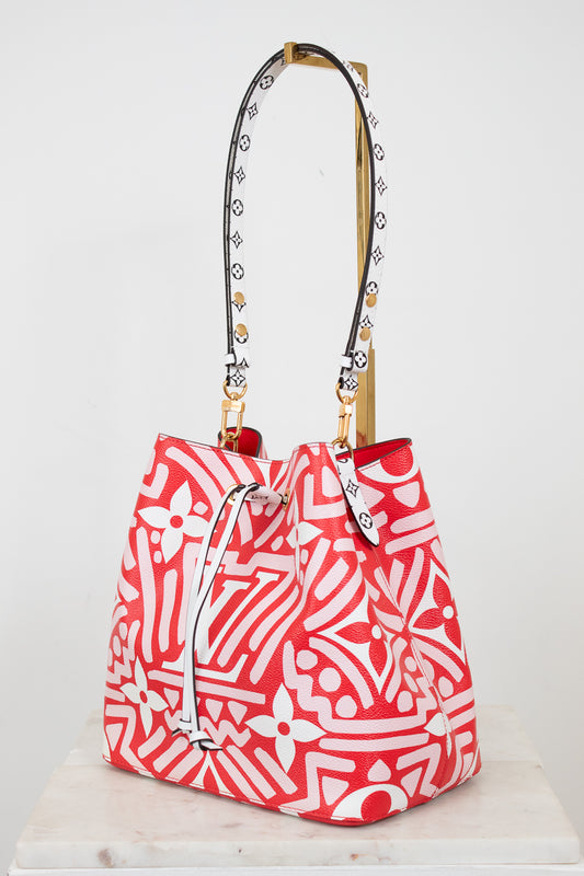 Red and white patterned handbag with a gold, black and white strap on a white background